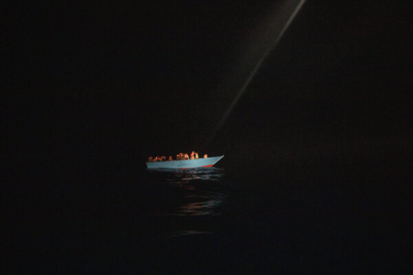 Dozens of migrants, from Egypt, Morocco, Somalia and Sierra Leone, including women and minors, wait to be assisted by a team of aid workers of the Spanish NGO Open Arms, after spending more than 20 hours at sea when fleeing Libya on board a precarious wooden boat in international waters, in the Central Mediterranean sea, Tuesday, Sept. 8, 2020. (AP Photo/Santi Palacios)