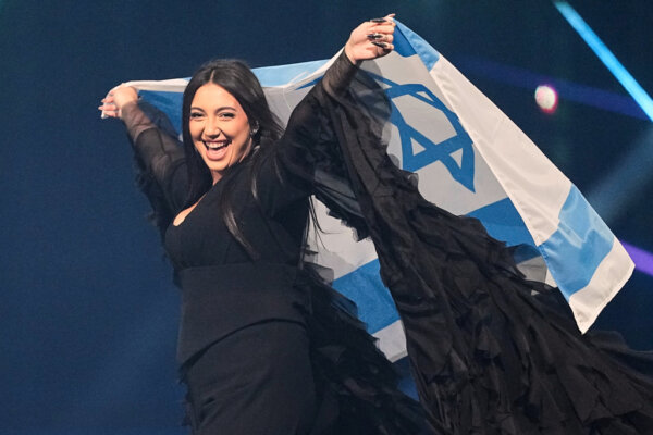 FILE - Singer Yuval Raphael, from Israel, holds the national flag during a dress rehearsal for the Grand Final of the 69th Eurovision Song Contest, May 16, 2025, in Basel, Switzerland. (AP Photo/Martin Meissner, File)